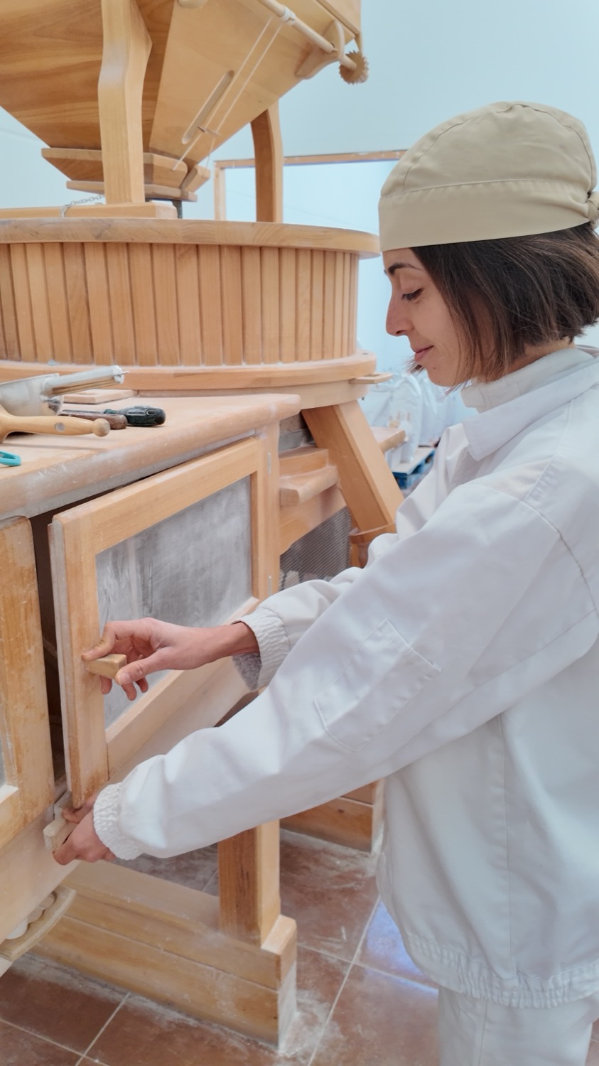 Almudena ajustando el cernedor del molino de piedra